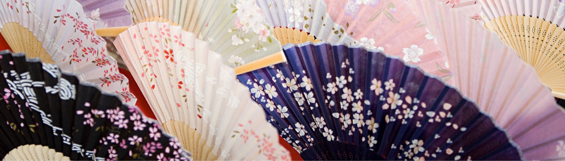 Japanese folding fans with colorful floral patterns arranged in a layered display