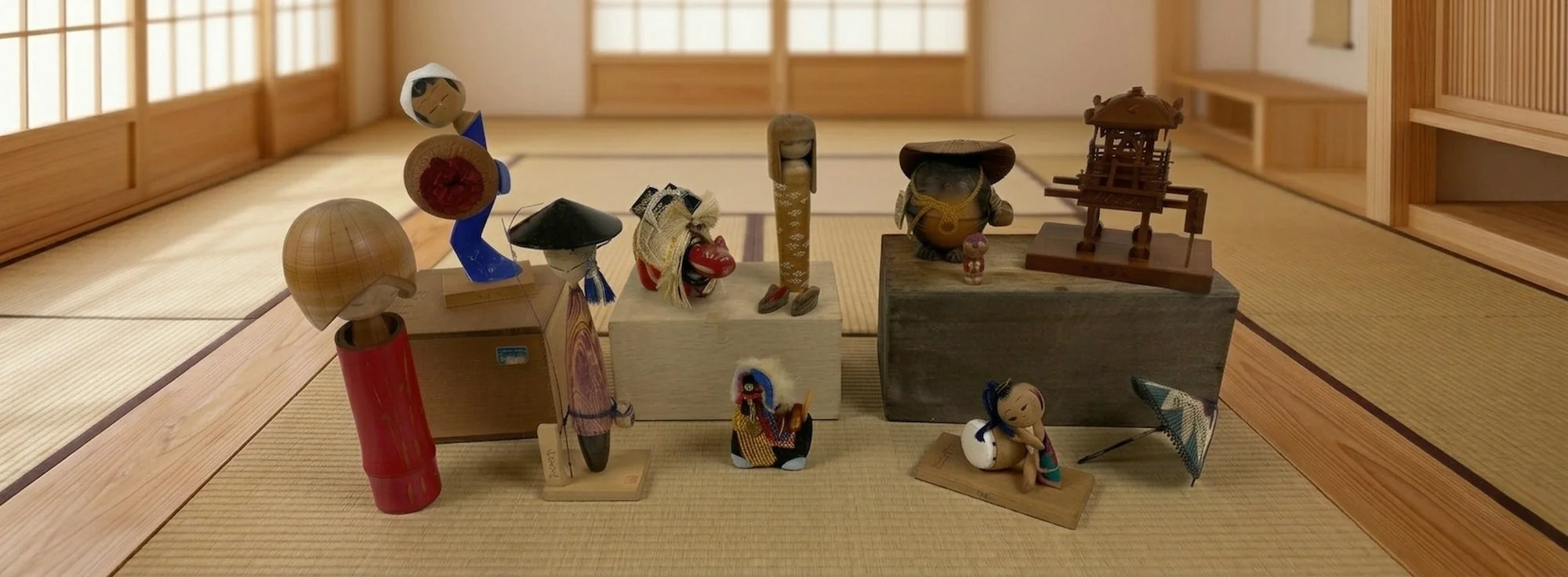 Vintage Japanese kokeshi dolls and traditional wooden folk art figures displayed in a tatami room with shoji screens.