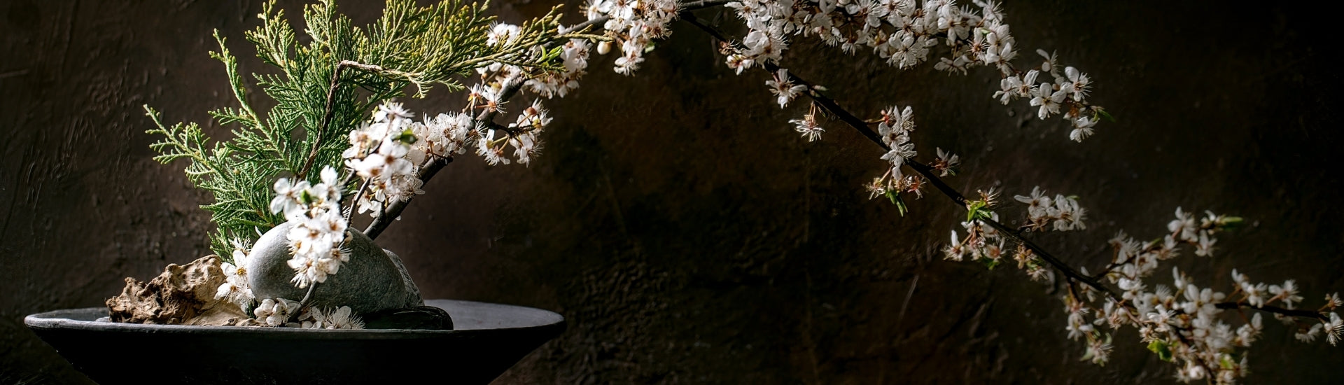 Japanese ikebana flower arrangement with branches and blossoms in a minimalist composition