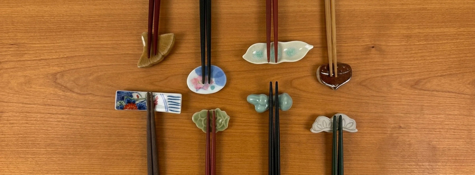 Vintage Japanese hashioki chopstick rests displayed with chopsticks on a warm wooden tabletop.